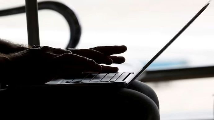 Seorang pria bekerja dengan laptop di bandara Hanoi, Vietnam, 18 Oktober 2017. (Foto: Dok/Kham/Reuters)