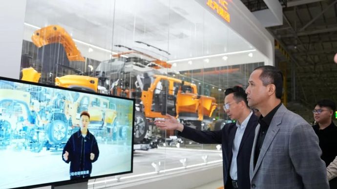 Menteri Transmigrasi Muhammad Iftitah Sulaiman Suryanagara (kanan) menyimak penjelasan mengenai teknologi dan proses produksi industri otomotif saat mengunjungi Beijing Automotive Group (BAIC Group) di Beijing, Tiongkok