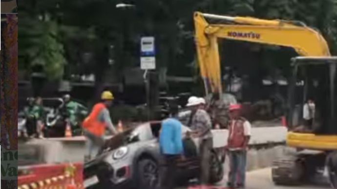 Sebuah mobil Mini Cooper dilaporkan terperosok ke lubang galian proyek di kawasan Greenville, Jakarta Barat, Senin (26/10/2026) sekira pukul 14.40 WIB.