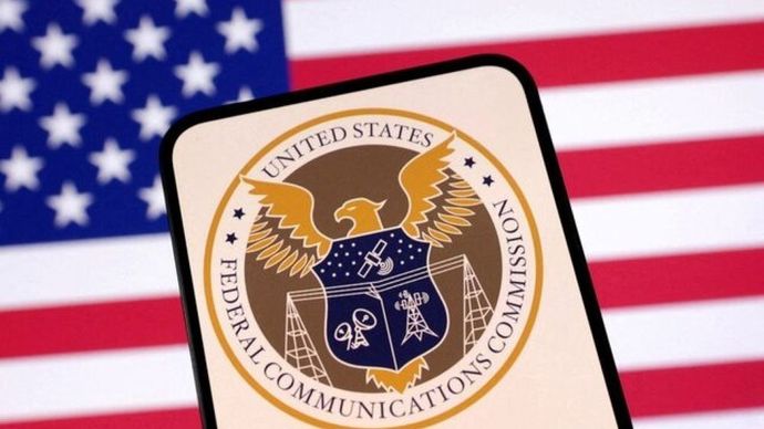 Logo Komisi Komunikasi Federal Amerika Serikat dan bendera AS terlihat dalam ilustrasi yang diambil pada 23 April 2025. (Foto: Dok/Dado Ruvic/Reuters)