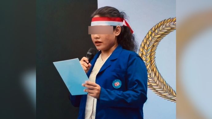 Perempuan mengenakan jaket almamater UBSI. 