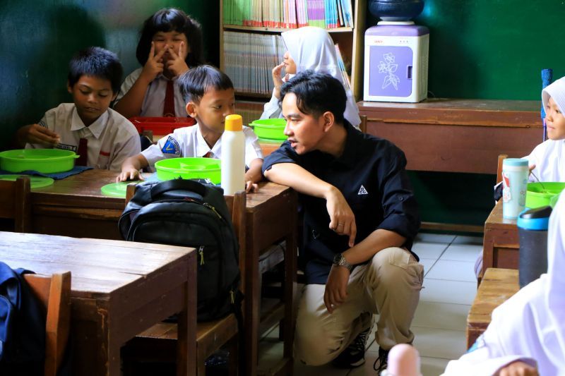 Wakil Presiden terpilih Gibran Rakabuming Raka berbincang dengan seorang siswa saat melakukan pemantauan program makan bergizi gratis di SDN 4 Tangerang, Senin (5/8/2024) <b>(ANTARA/HO-Pemkot Tangerang)</b>