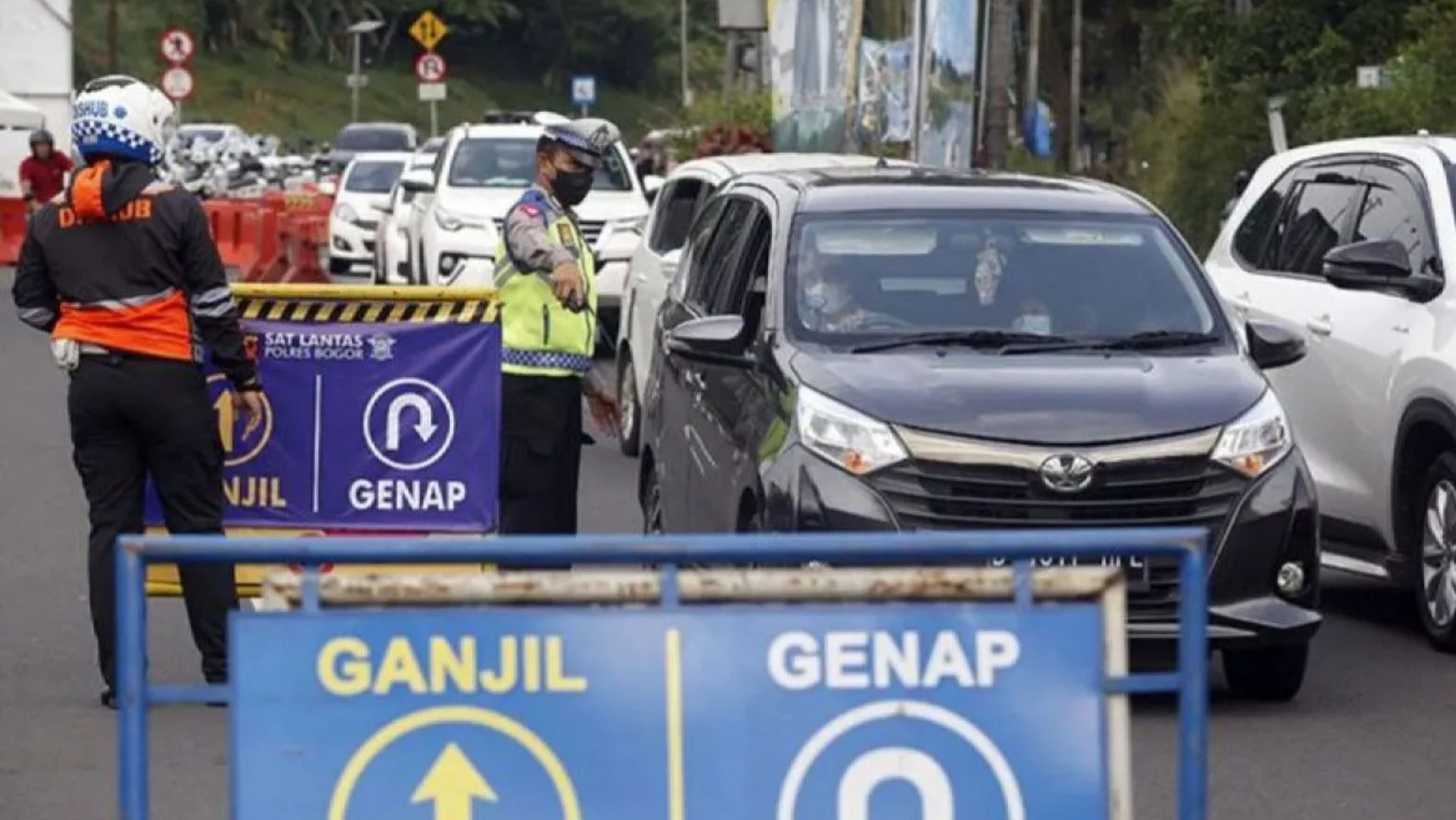 Petugas Sat Lantas Polres Bogor dan petugas Dishub Kabupaten Bogor mengarahkan kendaraan saat penyekatan kendaraan nomor polisi ganjil genap di jalur Puncak, Gadog, Kabupaten Bogor, Jawa Barat, <b>((Antara))</b>