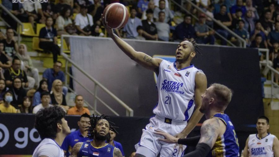 Pebasket Satria Muda Pertamina Jakarta Randy Bell (kedua kanan) melakukan lay up melewati adangan pebasket Prawira Harum Bandung Norbertas Giga (kanan) pada pertandingan pembuka Indonesia Basketball League (IBL) 2025 di C-Tra Prawira Arena, Bandung,  <b>(Dok.Antara)</b>