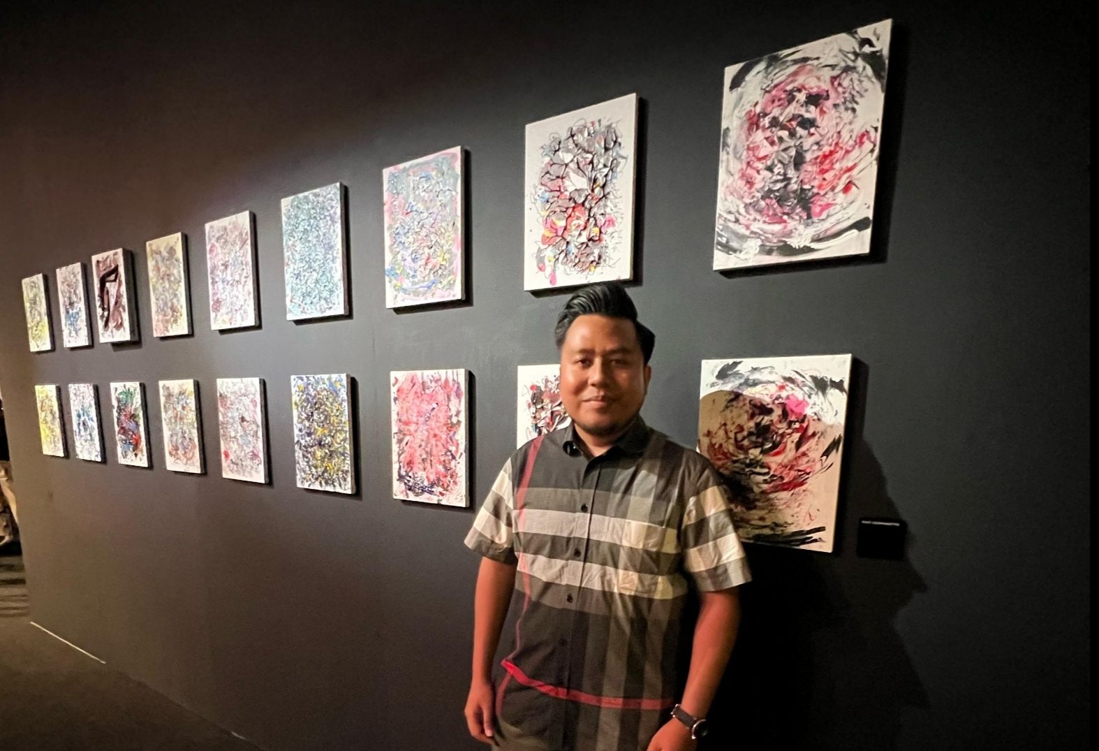 Direktur NT Corp Tommy William Tampubolon berpose di depan karya seni dalam pameran 
