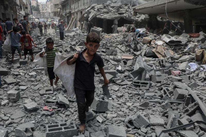 Anak-anak berjalan di atas reruntuhan bangunan setelah serangan udara Israel di wilayah Al-Rimal, sebelah barat Kota Gaza, pada 8 Agustus 2025. (Xinhua/Rizek Abdeljawad) <b>(Antara)</b>