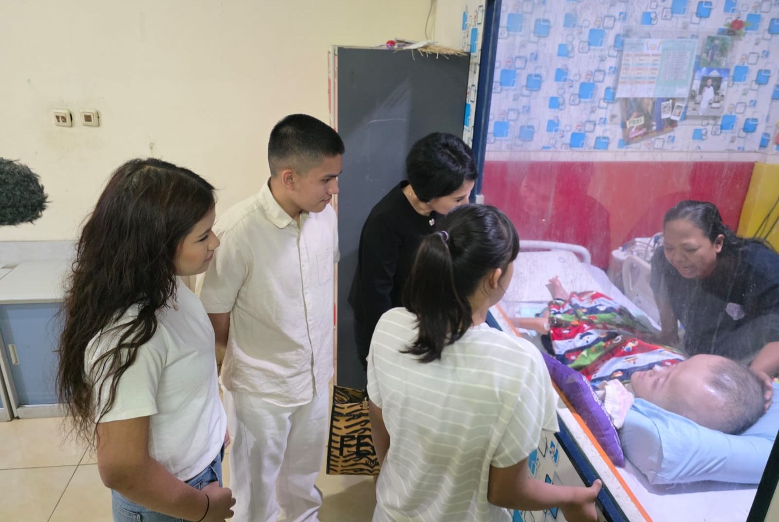 Natalia Rusli bersama kedua anaknya menyaksikan anak panti asuhan. 