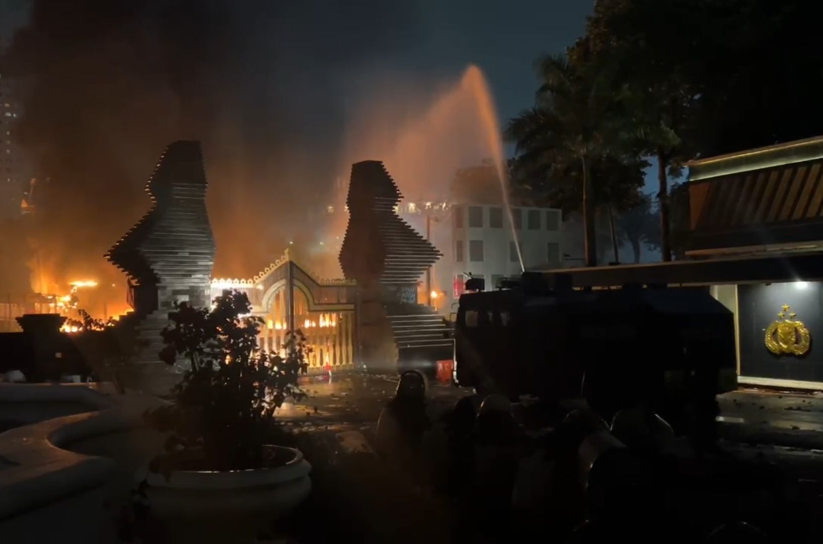Upaya pemadaman halte bus TransJakarta yang terbakar oleh polisi.  <b>(NTVNews.id)</b>