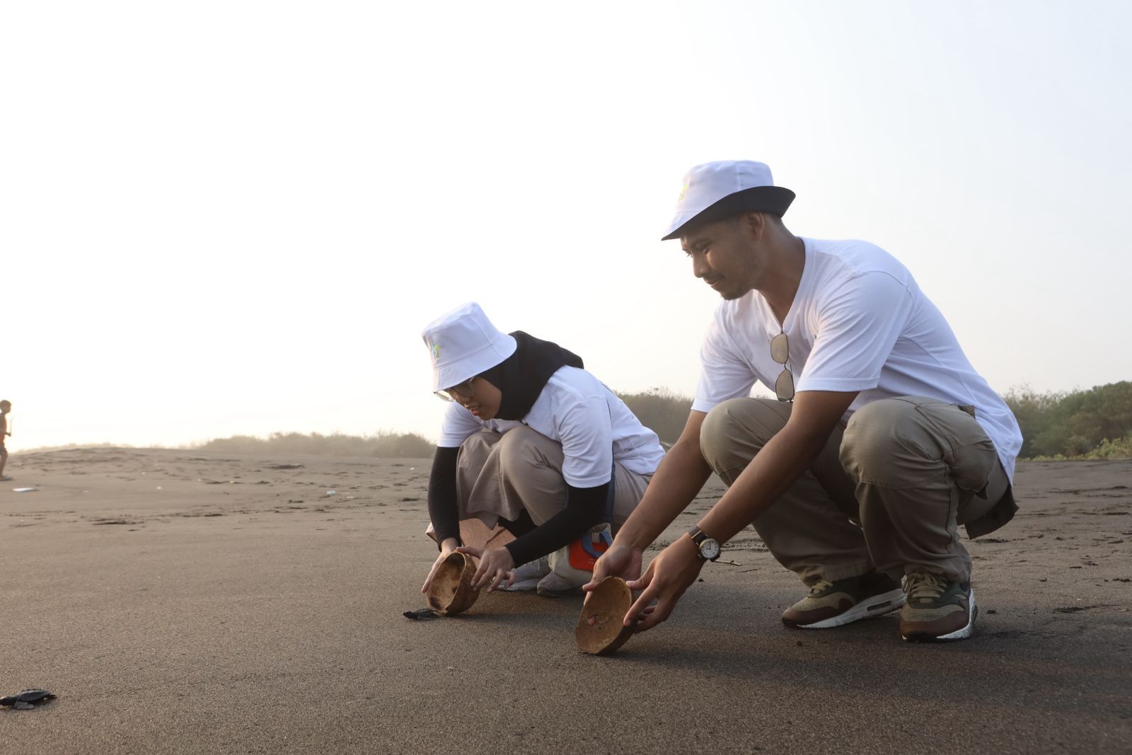 Relawan karyawan TelkomGroup melepas tukik di Pantai Pelangi, Bantul, Yogyakarta, sebagai simbol komitmen konservasi pesisir dalam program Telkom Connect-in: Penyu-lamat 2025. <b>(Telkom)</b>