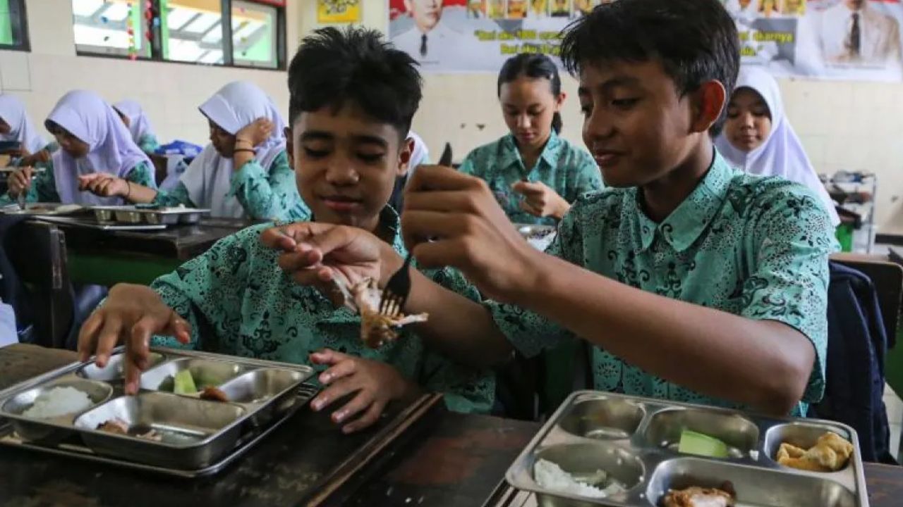Ilustrasi - Seorang siswa berbagi lauk pauk kepada teman sebangkunya saat menyantap makanan program Makan Bergizi Gratis (MBG) di SMP Negeri 9 Kota Semarang, Jawa Tengah, Selasa (9/9/2025). <b>(ANTARA)</b>