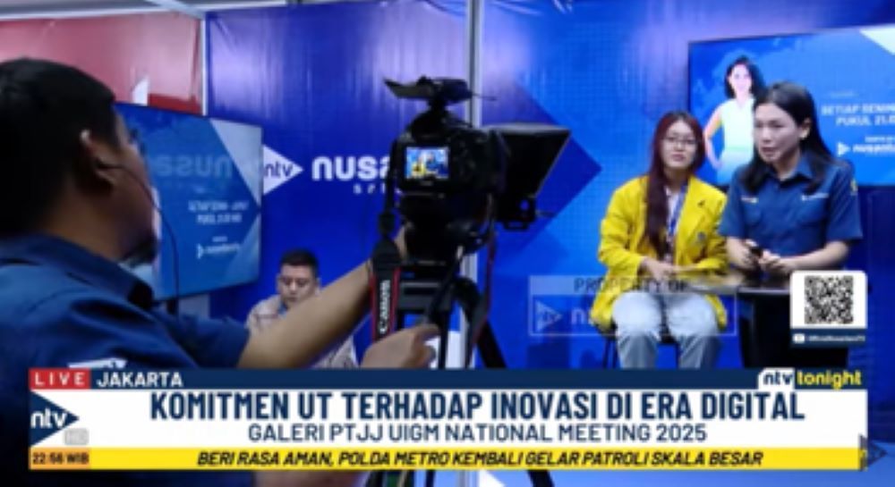 Jurnalis Nusantara TV memandu mahasiswi yang ingin mencoba simulasi menjadi presenter di booth mini Nusantara TV  