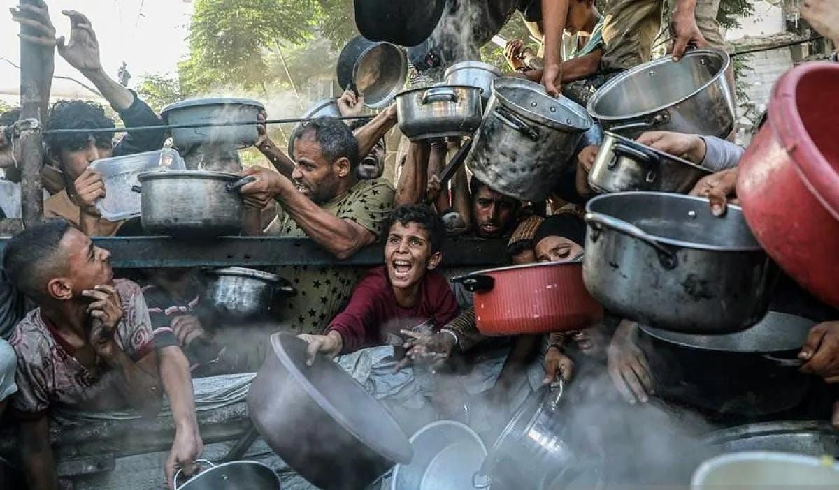 Arsip foto- Seorang anak bersama pengungsi lainnya menunggu pembagian makanan gratis dari pusat distribusi makanan di Kota Gaza, Palestina 14 Juli 2025. ANTARA/Xinhua/Rizek Abdeljawad/aa. <b>(Antara)</b>