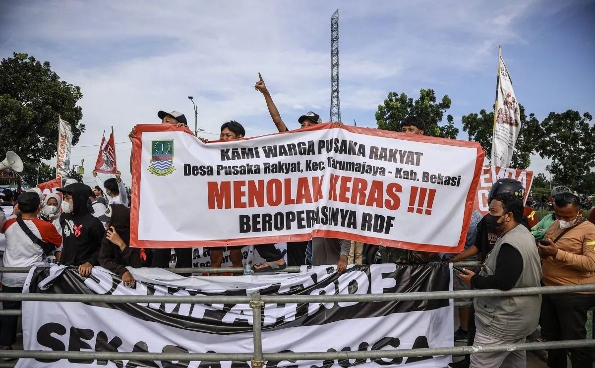 Warga membentangkan spanduk unjuk rasa di depan kawasan Refuse Derived Fuel (RDF) Plant, Rorotan, Jakarta Utara, Jumat, 21 Maret 2025. <b>(Antara/ Dhemas Reviyanto)</b>