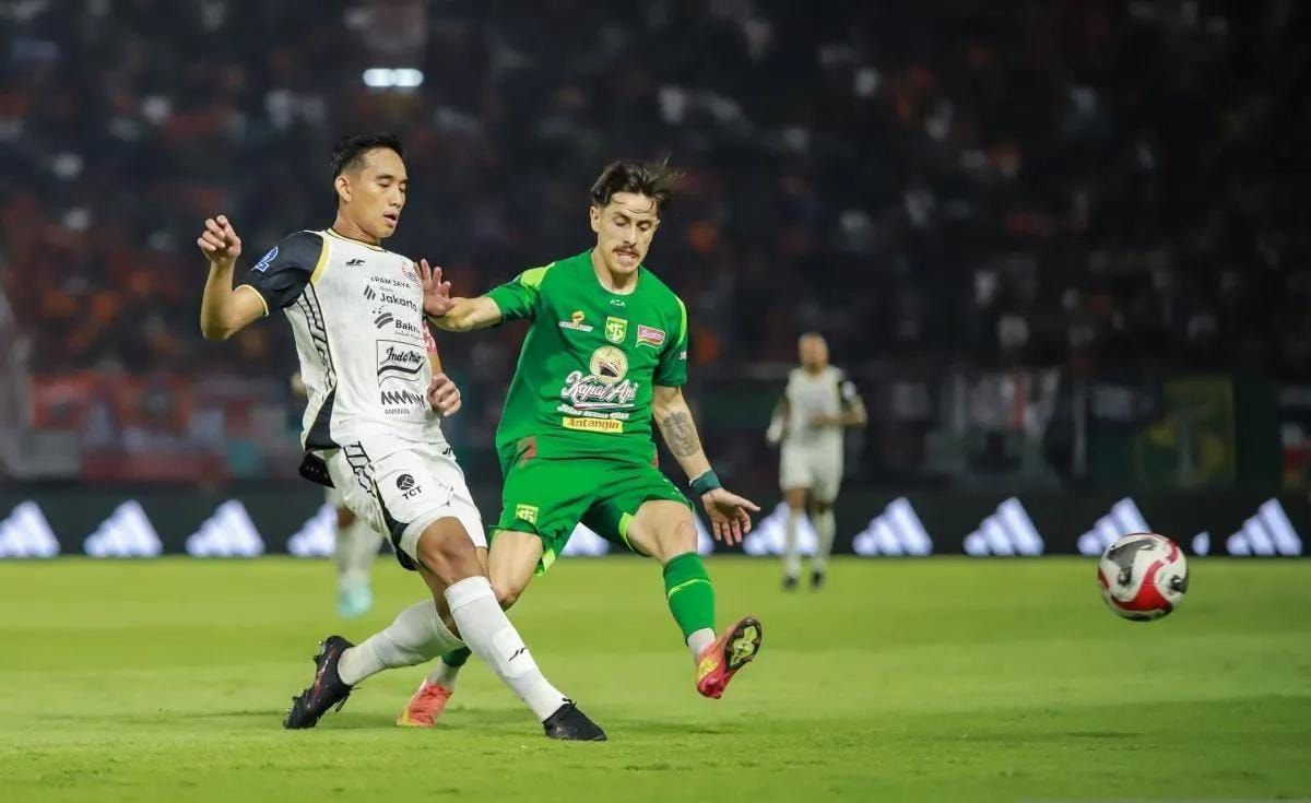 Kapten Persija Jakarta Rizky Ridho Ramadhani (kiri) berebut bola dengan pemain Persebaya Francisco Rivera (kanan) saat pertandingan pekan ke-9 BRI Super League 2025/2026 di Stadion GBT Surabaya, Sabtu 18 Oktober 2025 malam. ANTARA/Rizal Hanafi <b>(Antara)</b>