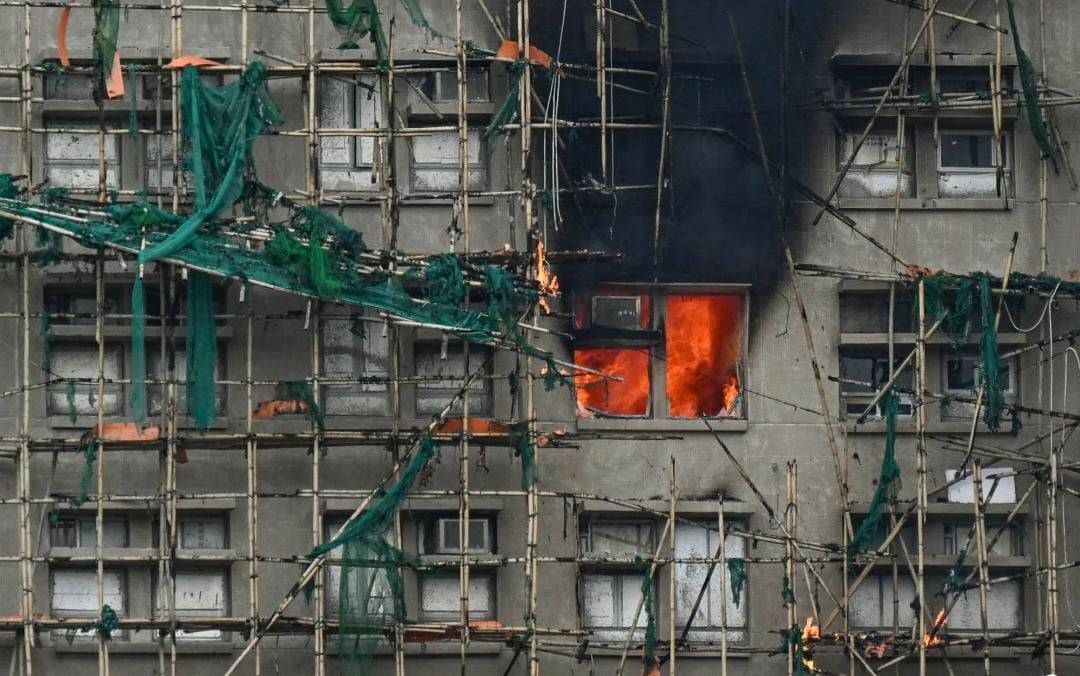 Api terlihat di sebuah flat pada 27 November 2025, setelah kebakaran besar melanda beberapa blok apartemen di kompleks perumahan Wang Fuk Court di distrik Tai Po, Hong Kong, pada 27 November 2025. (Foto: AFP/Peter&nbsp;Parks) <b>(CNA)</b>