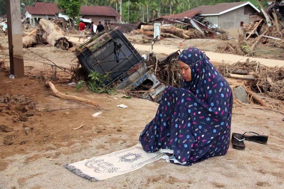 Warga menunaikan shalat di area rumah yang rusak akibat banjir bandang di Desa Aek Garoga, Kecamatan Batang Toru, Kabupaten Tapanuli Selatan, Sumatera Utara, Minggu (30/11/2025). Bencana banjir bandang yang terjadi pada Selasa (25/11) lalu menyebabka <b>(Antara)</b>