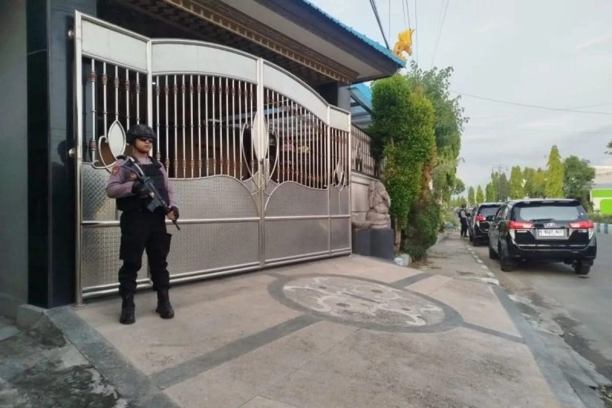 Polisibersenjata lengkap berjaga di luar rumah Heru Sungoko, pejabat KONI sekaligus pengusaha swasta diduga terkait penyelidikan korupsi proyek pembangunan Monumen Reog dan Museum Peradaban (MRMP) Ponorogp, Jumat 28 November 2025. ANTARA/HO - Prastyo <b>(Antara)</b>