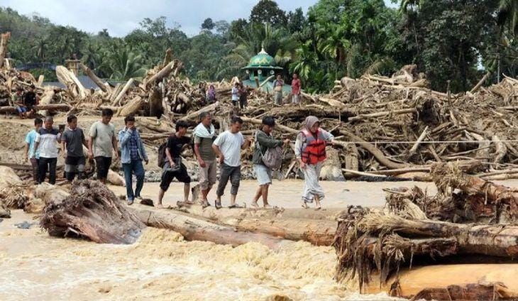 Warga berjalan melintasi sungai dengan jembatan darurat di Desa Aek Garoga, Kecamatan Batang Toru, Kabupaten Tapanuli Selatan, Sumatera Utara, Sabtu (29/11/2025). Warga terpaksa melintasi jembatan darurat dari batang kayu akibat jalan dan jembatan penghubung antara Kabupaten Tapanuli Selatan menuju Tapanuli Tengah-Sibolga serta Medan putus diterjang banjir bandang pada Selasa 29 November 2025.ANTARA FOTO/Yudi Manar/bar/pri. <b>(Antara)</b>
