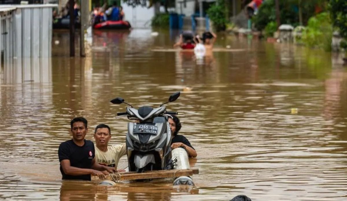 Warga mendorong perahu yang membawa sepeda motor saat melintasi banjir di Baleendah, Kabupaten Bandung, Jawa Barat, Sabtu, 6 Desember 2025. Banjir yang terjadi di Kabupaten Bandung meluas hingga berdampak ke 14 kecamatan dengan volume air yang mengal <b>(Antara)</b>