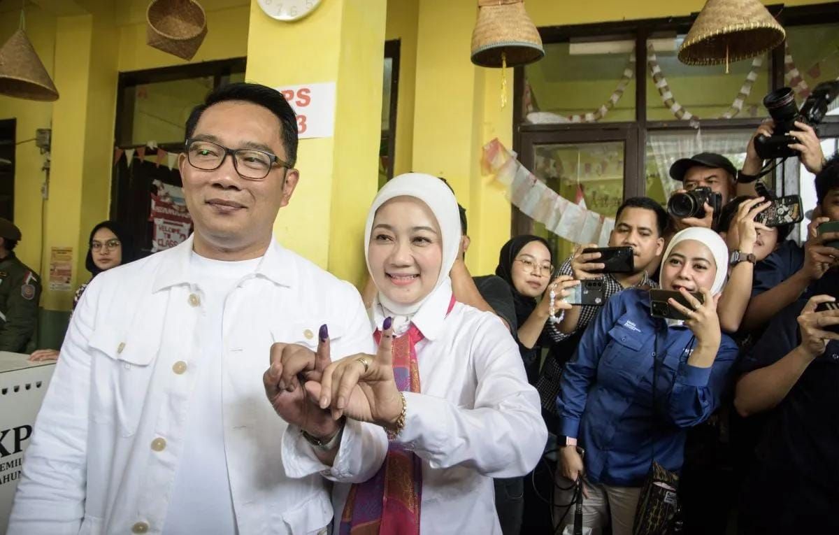 Arsip foto- Calon gubernur (Cagub) DKI Jakarta nomor urut 1 Ridwan Kamil (kiri) bersama istri sekaligus Anggota Komisi VIII DPR RI Atalia Praratya (kedua kiri) menunjukkan tinta pada jari usai menggunakan hak pilihnya menggunakan hak pilihnya pada pi <b>(Antara)</b>