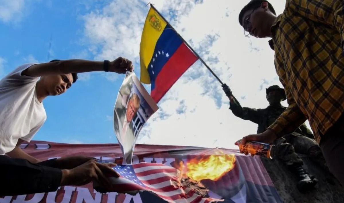 Pengunjuk rasa dari berbagai aliansi membakar bendera AS dan poster bergambar presiden AS Donald Trump saat menggelar aksi solidaritas untuk Venezuela di depan Kedutaan Besar Amerika Serikat, Jakarta, Selasa, 6 Januari 2026. ANTARA FOTO/Indrianto Eko <b>(Antara)</b>