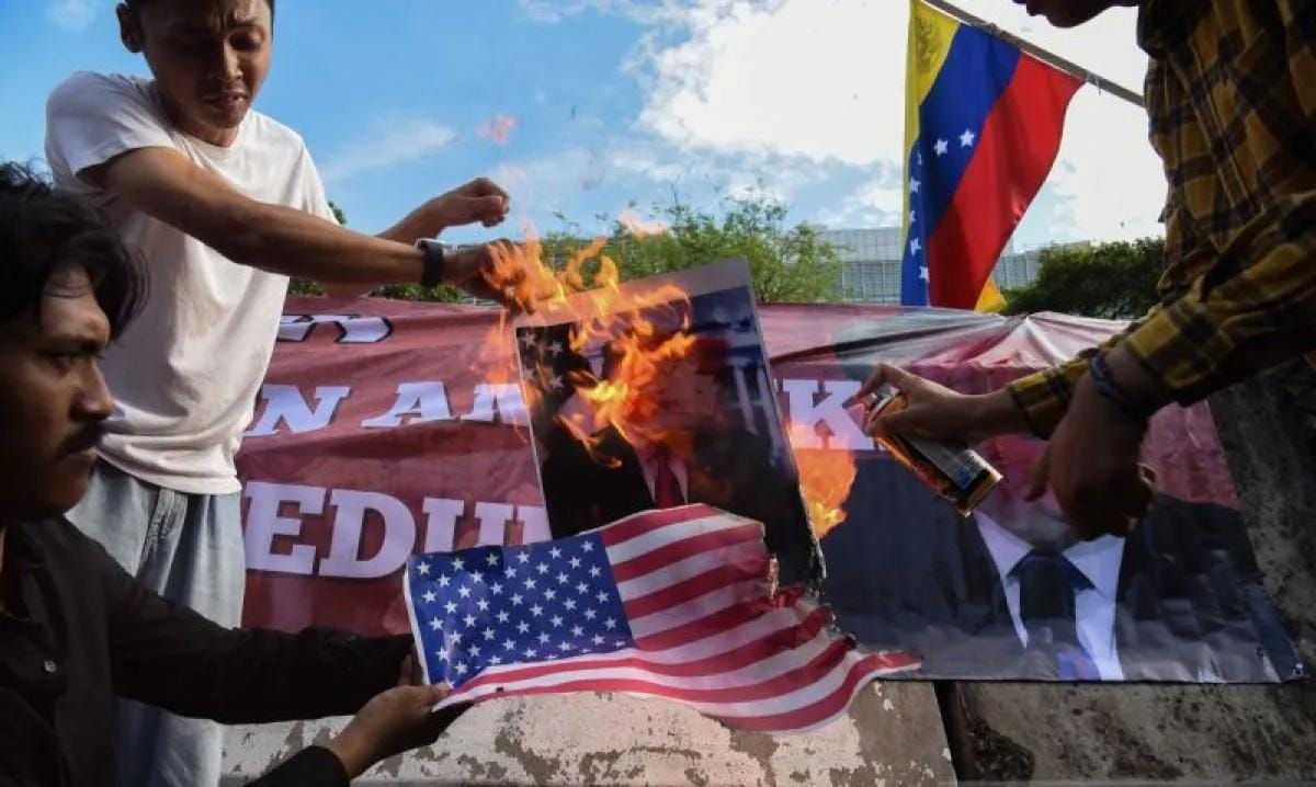 Pengunjuk rasa dari berbagai aliansi membakar bendera AS dan poster bergambar presiden AS Donald Trump saat menggelar aksi solidaritas untuk Venezuela di depan Kedutaan Besar Amerika Serikat, Jakarta, Selasa (6/1/2026). Dalam aksi solidaritas tersebu <b>(Antara)</b>