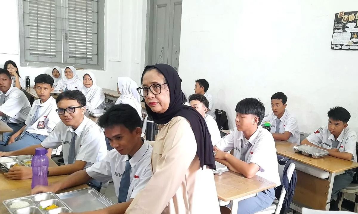 Wakil Kepala BGN Nanik Sudaryati Deyang berbincang dengan salah satu siswa SMK Negeri 1 Jakarta pada Kamis, 8 Januari 2026 pada penyaluran MBG hari pertama di sekolah tahun 2026. ANTARA/Lintang Budiyanti Prameswari. <b>(Antara)</b>