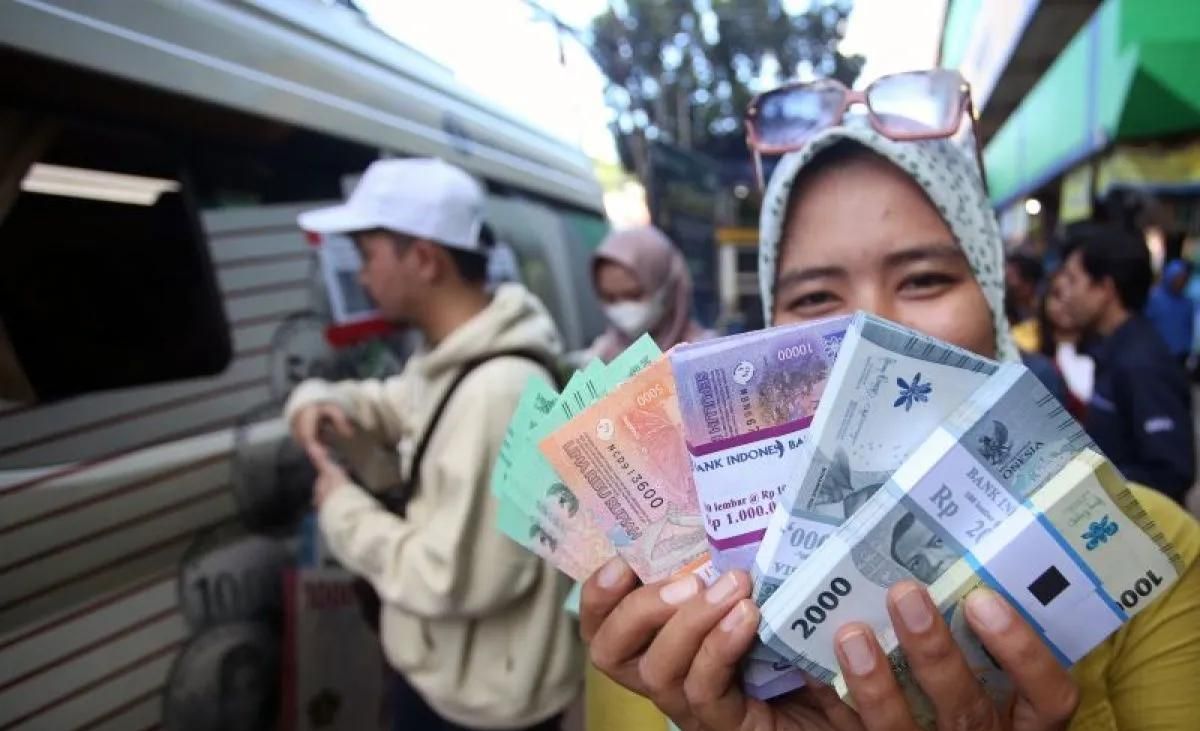 Arsip foto - Warga menunjukan uang rupiah baru yang baru saja ditukarkan pada mobil kas keliling Bank Indonesia (BI) di Pasar Palmerah, Jakarta, Senin, 18 Maret 2024. ANTARA FOTO/Muhammad Iqbal. <b>(Antara)</b>