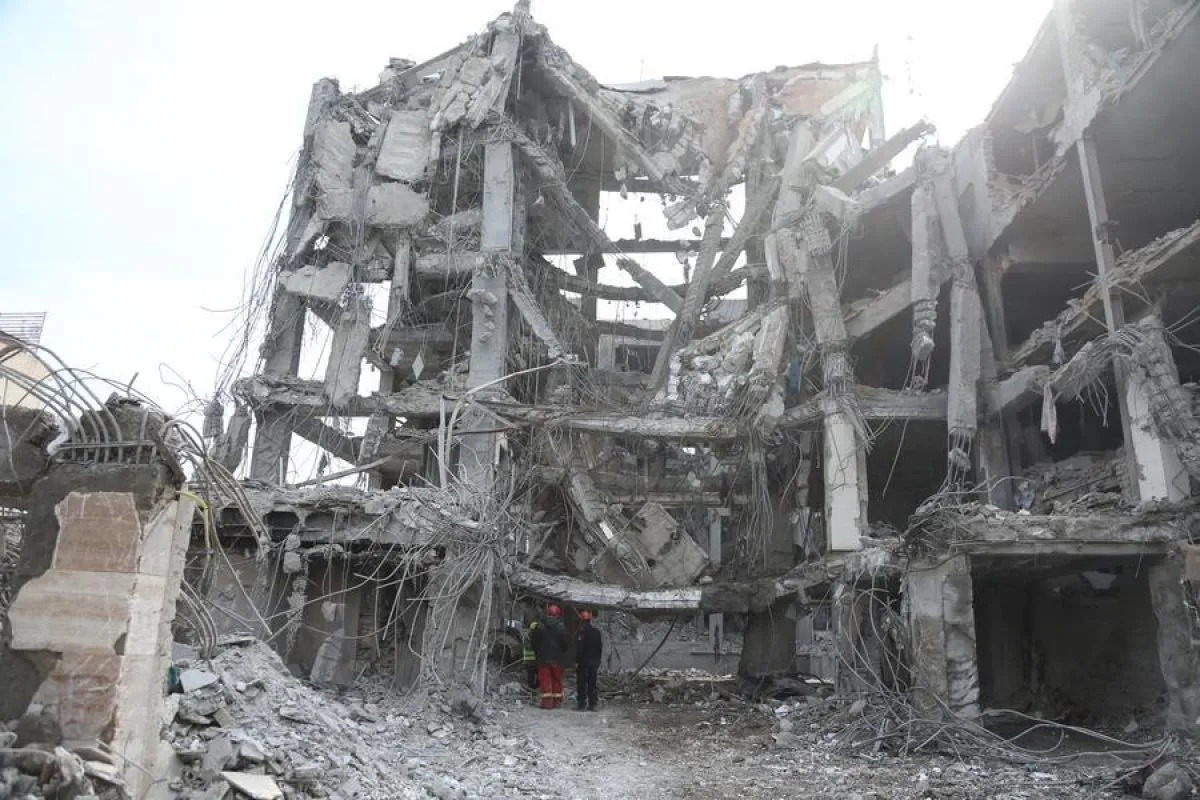 Orang-orang bekerja di depang bangunan yang rusak di Teheran, Iran, pada 12 Maret 2026. (ANTARA/Xinhua/Shadati) <b>(Antara)</b>