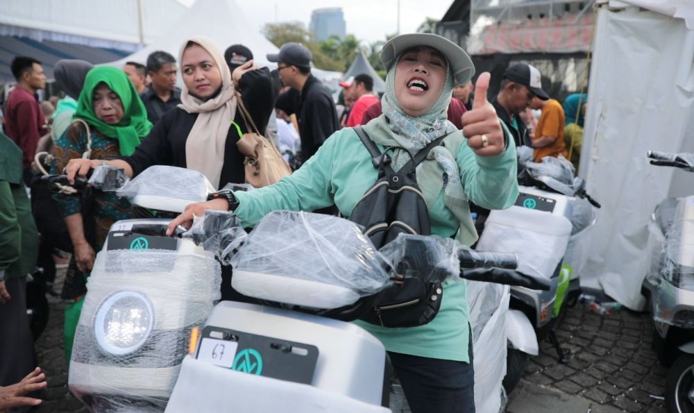 Warga Jakarta Selatan, Diana, memenangkan hadiah undian motor listrik di pasar murah pemerintah di Monas. (Foto: Dok/Istimewa/Bakom RI) 