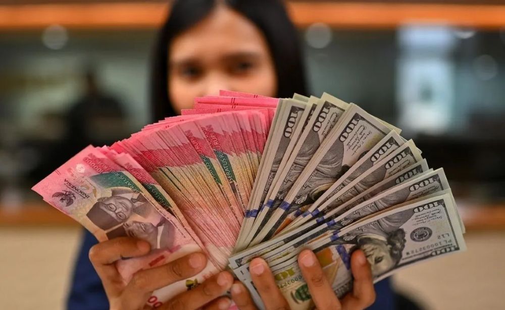 Karyawan memperlihatkan uang pecahan rupiah dan dolar Amerika Serikat (AS) di gerai penukaran mata uang asing Ayu Masagung, Jakarta, Selasa (12/5/2026). (Foto: ANTARA FOTO/Indrianto Eko Suwarso/kye)