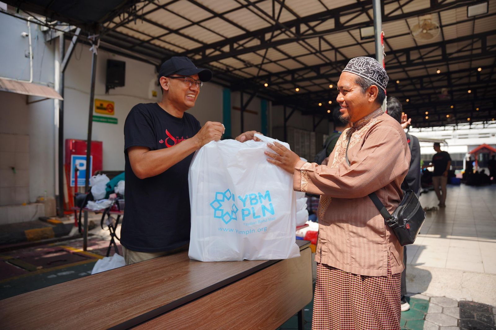 Tampak personel Yayasan Baitul Maal PLN menyerahkan sedekah daging kepada penerima manfaat, salah satu pengurus panti asuhan di Surabaya. (Foto: Dok/Istimewa)