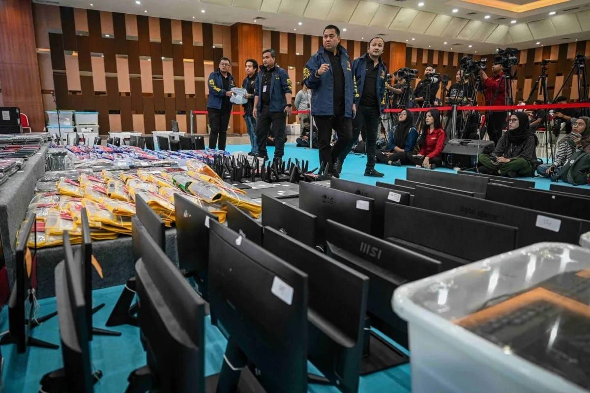 Petugas kepolisian mengecek barang bukti yang ditampilkan saat konferensi pers kasus judi online jaringan internasional, di Bareskrim Mabes Polri, Jakarta, Jumat, 26 Juni 2026. Direktorat Tindak Pidana Umum (Dittipidum) Bareskrim Polri menetapkan 287 <b>(Antara)</b>