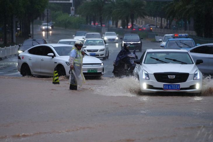 Seorang petugas polisi mengatur lalu lintas di ruas jalan yang tergenang air di Nanning, Daerah Otonomi Guangxi Zhuang, China, Minggu, 5 Juli 2026. (Xinhua/Zhou Hua) <b>(Antara)</b>