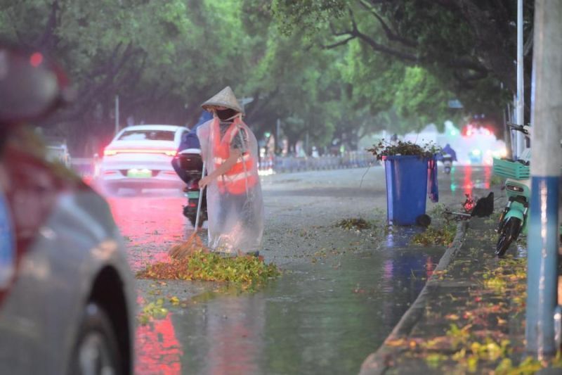 Seorang petugas kebersihan membersihkan jalan di tengah hujan di Distrik Haicheng, Beihai, Daerah Otonom Etnis Zhuang Guangxi, China, pada Minggu, 5 Juli 2026. (Xinhua/Li Junguang) <b>(Antara)</b>
