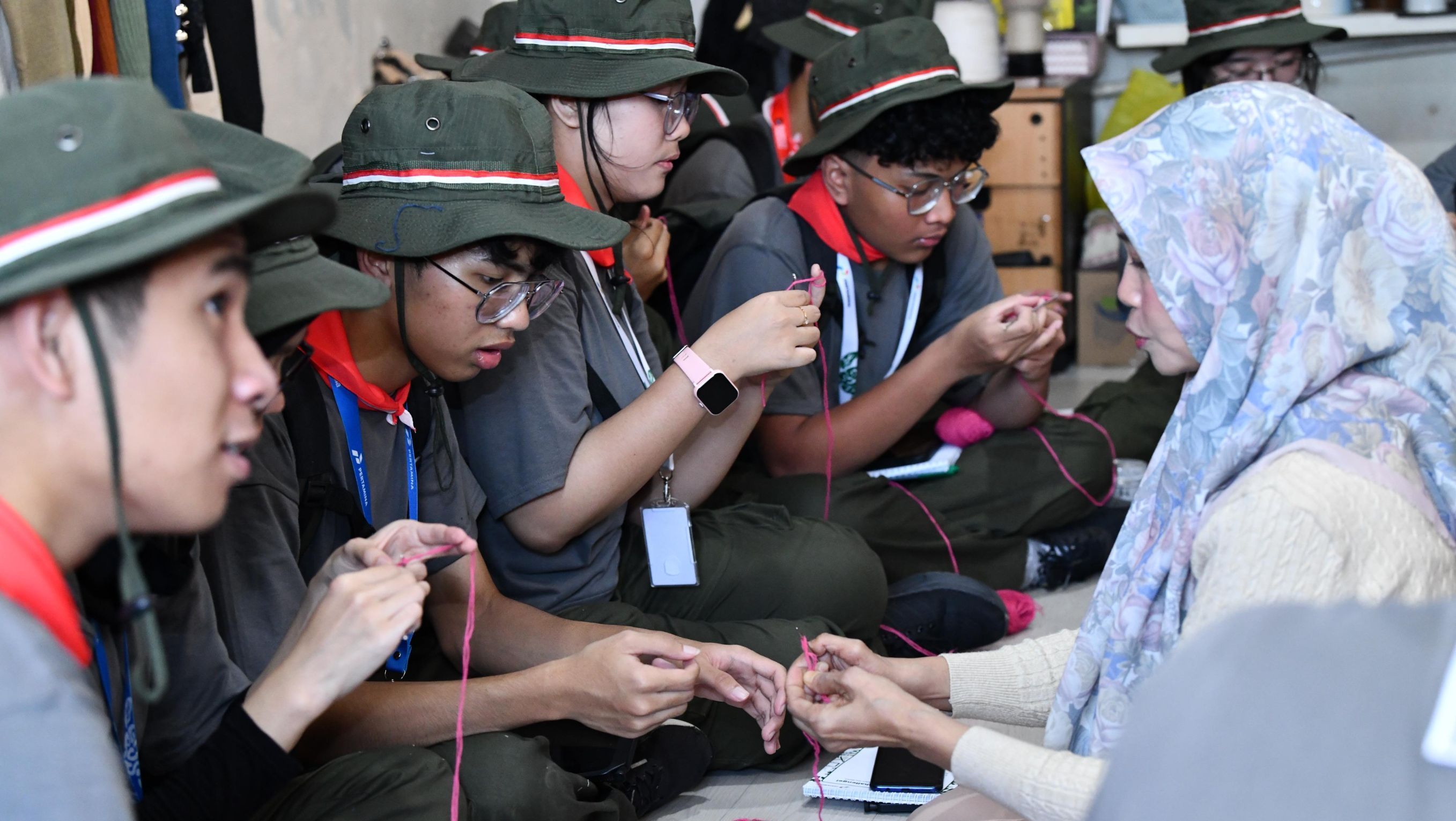  Penyandang disabilitas tuna daksa sekaligus perajut kain, Elis Juarsih (47) mengajarkan cara membuat gelang dengan merajut benang kepada anggota Green Warriors diacara Green Bus Pertamina 2026, rabu (8/7) di Kampoeng Radjoet Binong. <b>(Pertamina)</b>