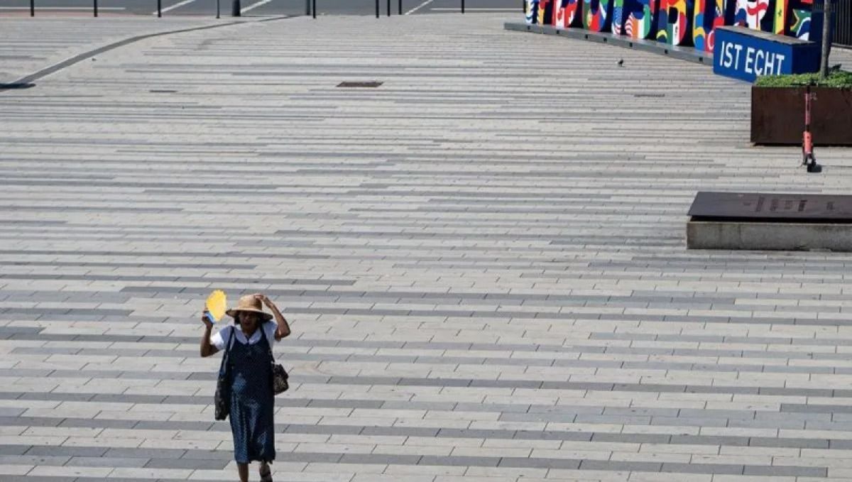 Seorang wanita berjalan di bawah sinar matahari saat gelombang panas dengan suhu mendekati 40 derajat Celsius di Duisburg, Jerman, Rabu, 24 Juni 2026. <b>(Antara)</b>