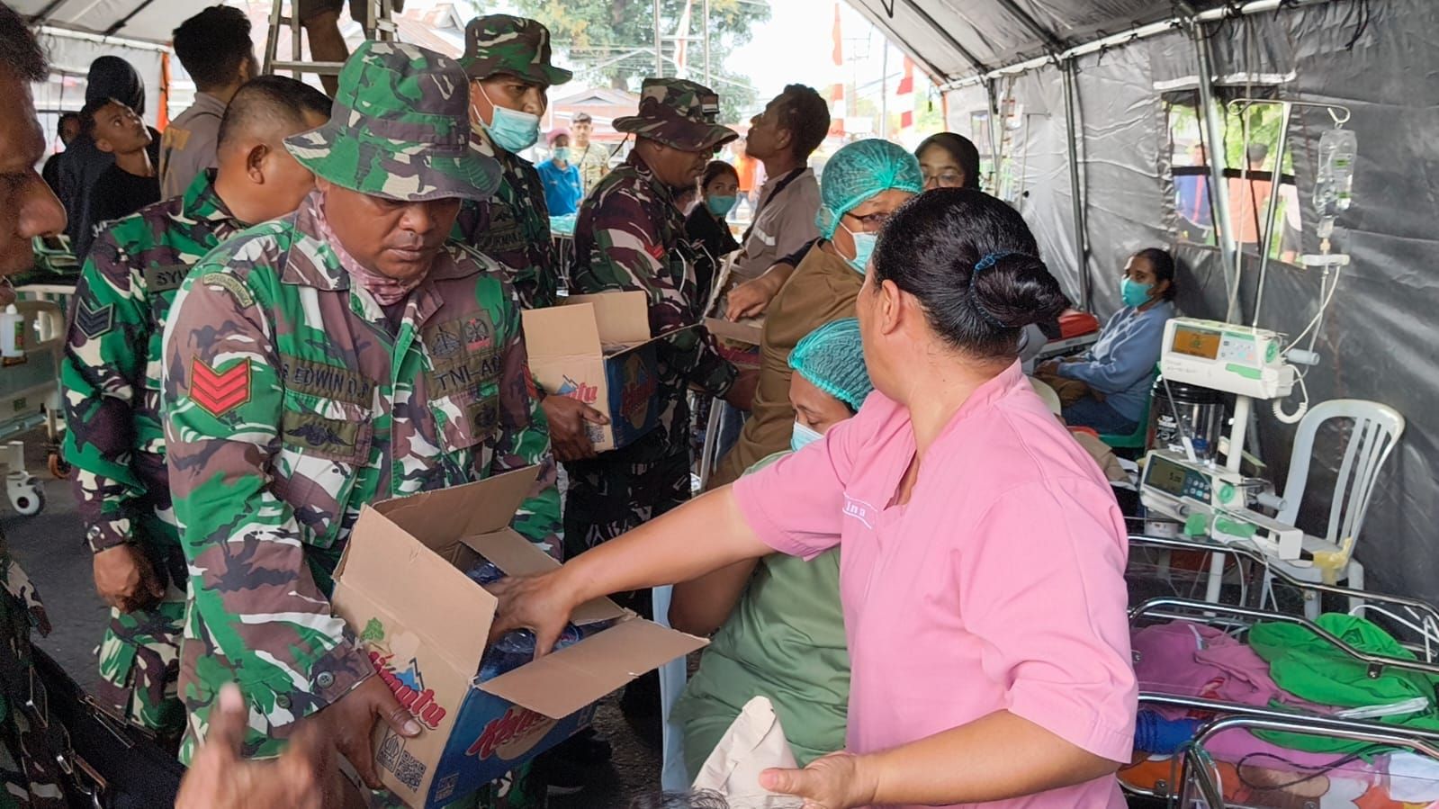 Prajurit TNI membantu menyalurkan makanan dan minuman kepada korban gempa NTT. 