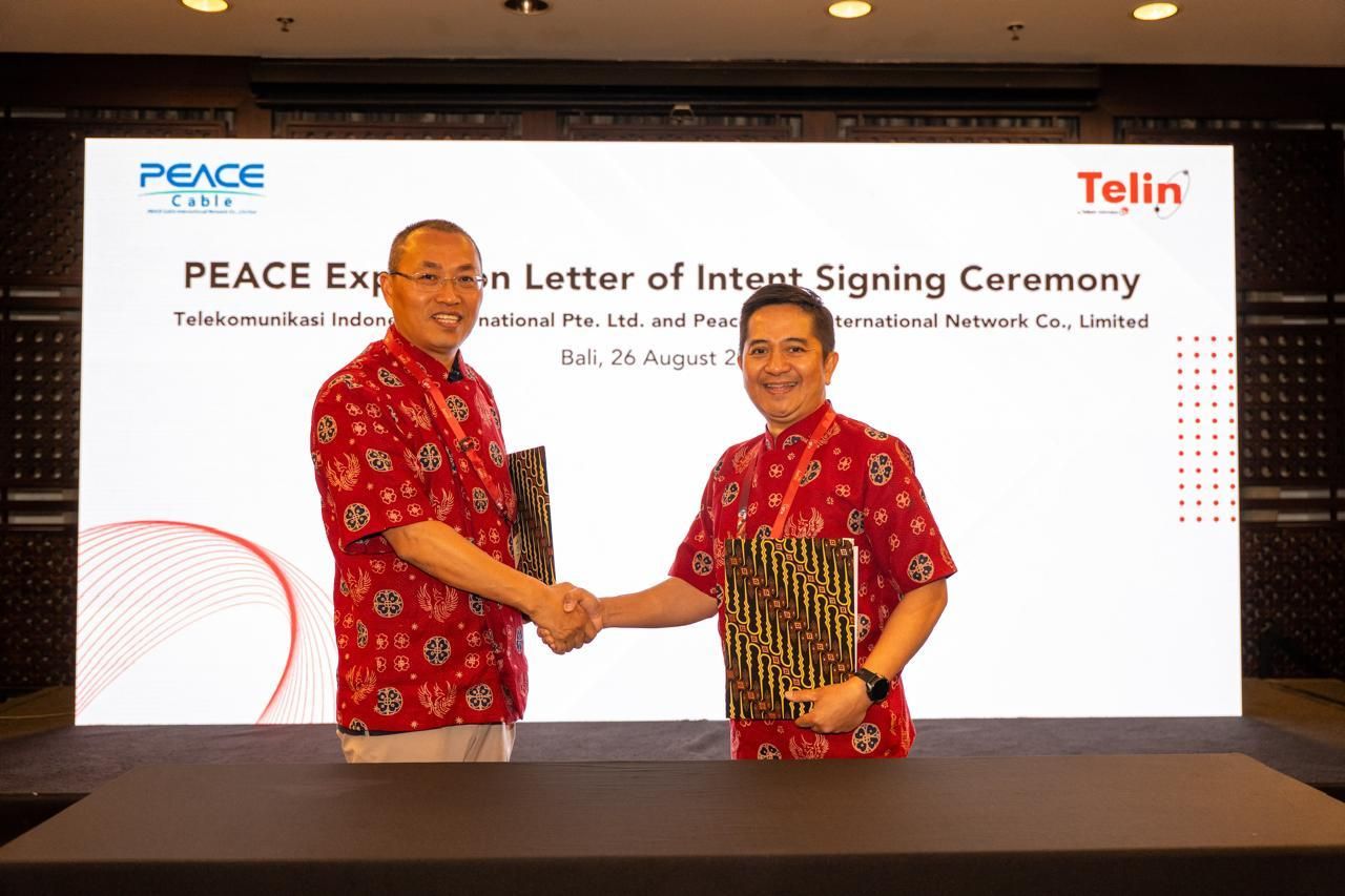 CEO Telin in Singapore Indarto dan CEO PEACE Cable International Network Co., Limited Sun Xiaohua berjabat tangan usai penandatanganan Letter of Intent (LOI) dalam rangkaian BATIC 2026 di Bali. <b>(Telin)</b>