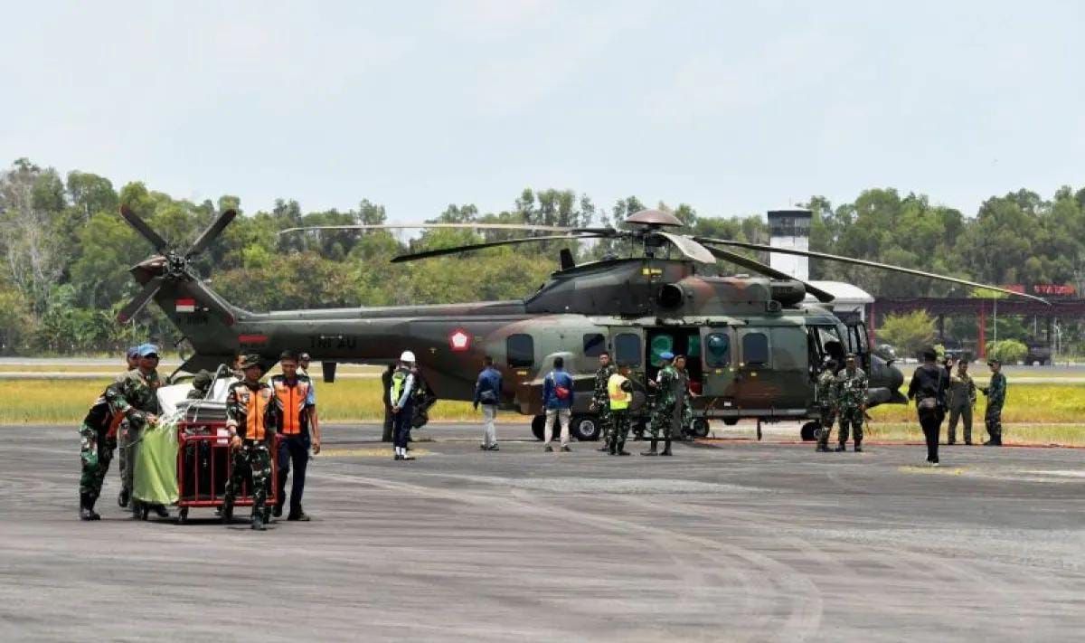 Personel membawa peralatan saat kedatangan pesawat jenis Airbus Helicopters H225 di Bandara Sultan Aji Muhammad Sulaiman Sepinggan, Balikpapan, Kalimantan Timur, Jumat, 4 September 2026. TNI AU memberikan bantuan 1 unit pesawat jenis Airbus Helicopters H225 dengan kapasitas angkut 2000 liter air yang akan digunakan untuk pemadaman karhutla di wilayah Ibu Kota Nusantara (IKN) <b>(Antara)</b>