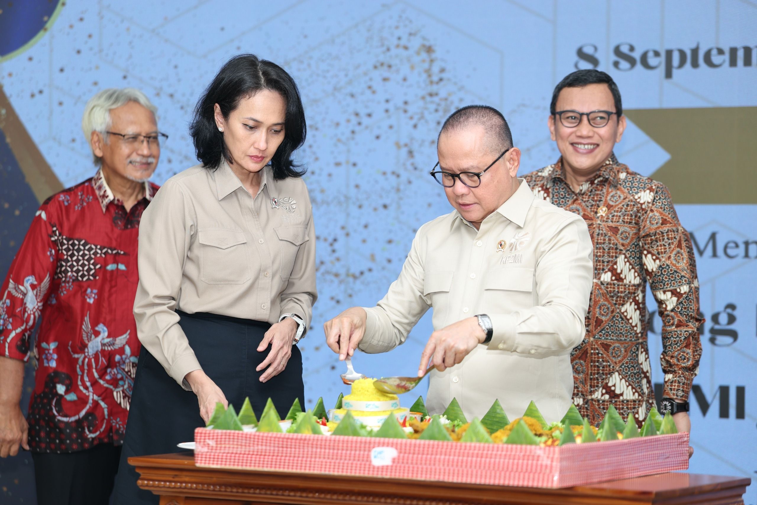 Menteri P2MI Mukhtarudin melakukan pemotongan tumpeng, simbol rasa syukur dan pencapaian atas satu tahun perjalanan Kementerian P2MI. Beliau didampingi oleh Wakil Menteri dan para staf ahli.