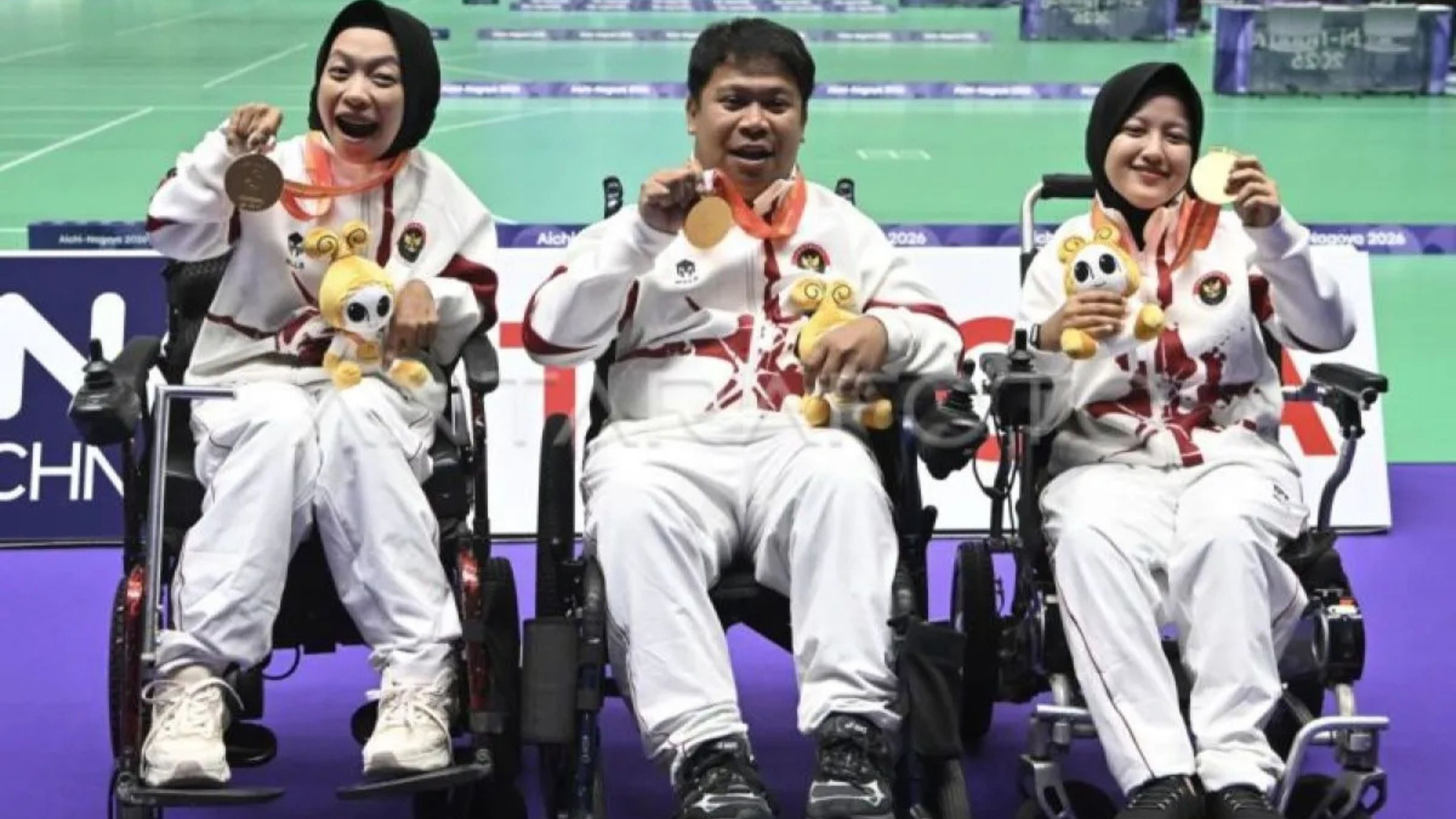 Atlet boccia Indonesia Felix Ardi Yudha (tengah), didampingi kompatriotnya Gischa Zayana (kanan) dan Handayani (kiri), menunjukkan medali emas yang diraihnya pada Asian Para Games 2026. <b>(ANTARA)</b>