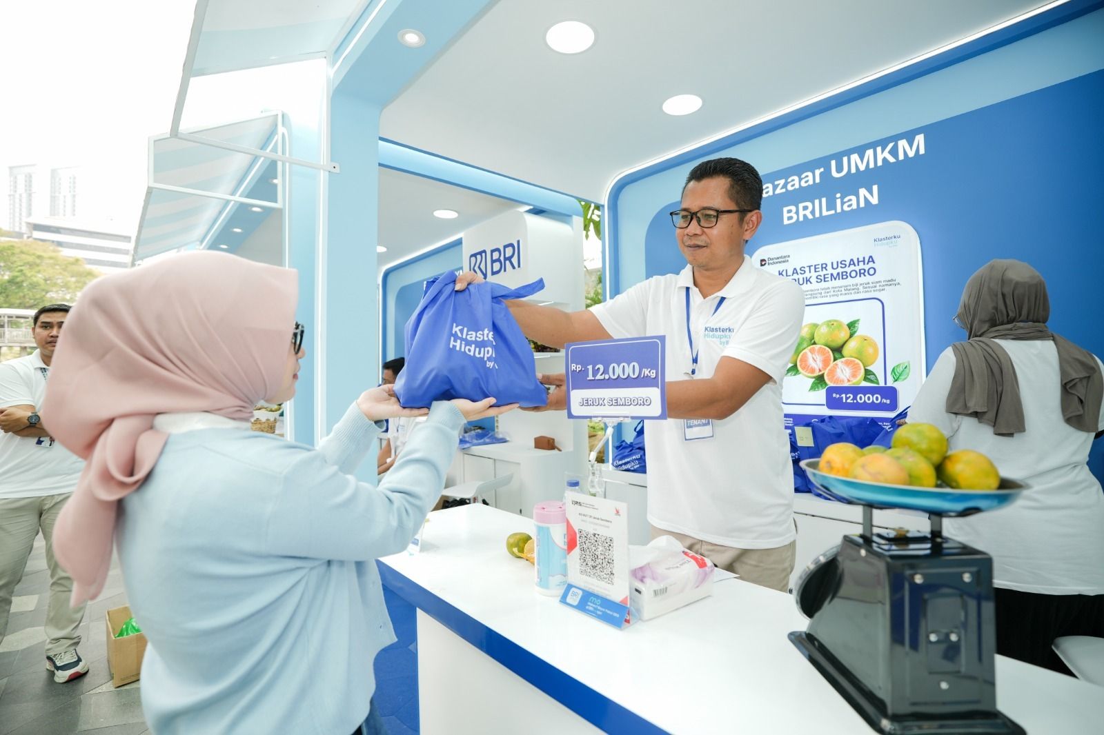 Antoni saat melayani pembeli di gerai Klaster Usaha Jeruk Semboro dalam ajang bazar UMKM, sebagai bagian dari upaya pembinaan dan perluasan pasar produk lokal melalui program pemberdayaan BRI.