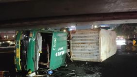 Sebuah truk kontainer mengalami kecelakaan hingga terguling di bawah kolong flyover lampu merah Tomang, Jakarta Barat, Selasa sore, 12 Mei 2026.
