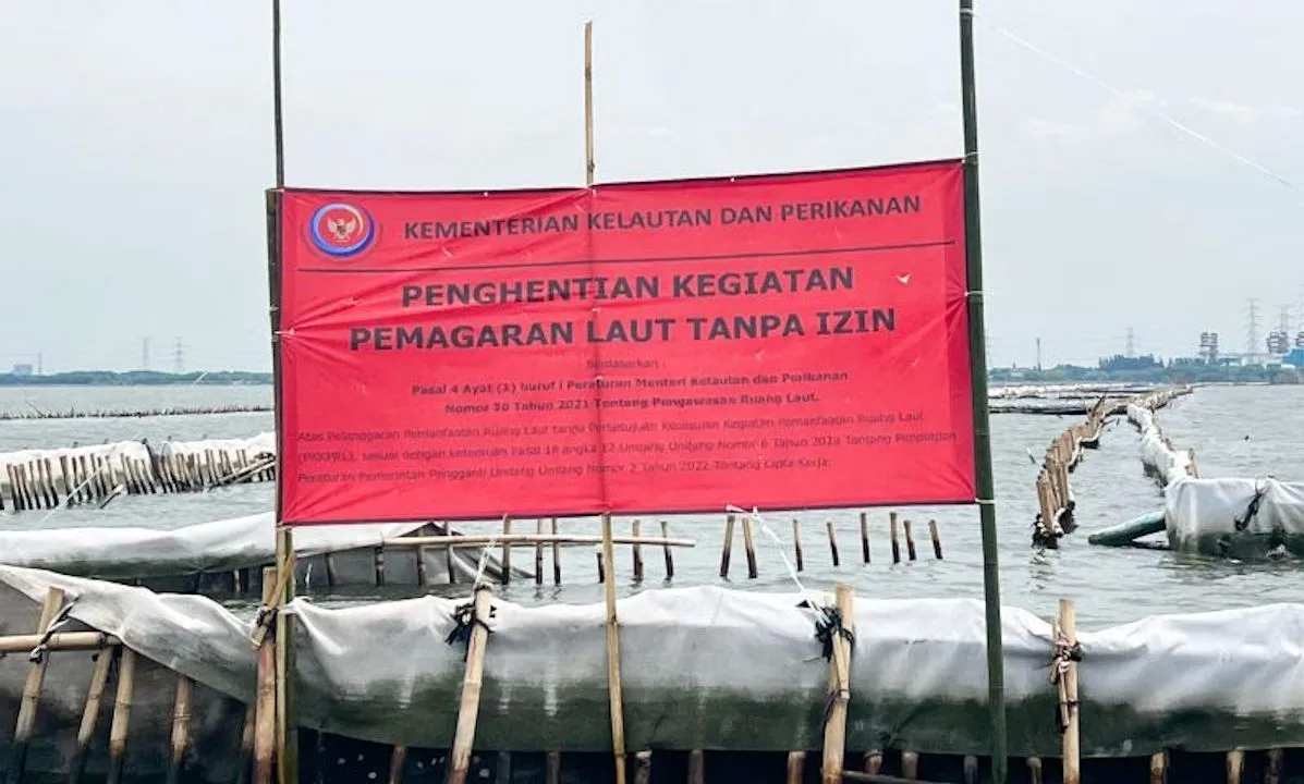 Arsip Foto - Spanduk berwarna merah dari KKP bertuliskan Kementerian Kelautan dan Perikanan Penghentian Kegiatan Reklamasi Tanpa PKKPRL terpasang di pagar laut perairan Bekasi, Jawa Barat, Rabu (15/1/2025) <b>(Antara)</b>