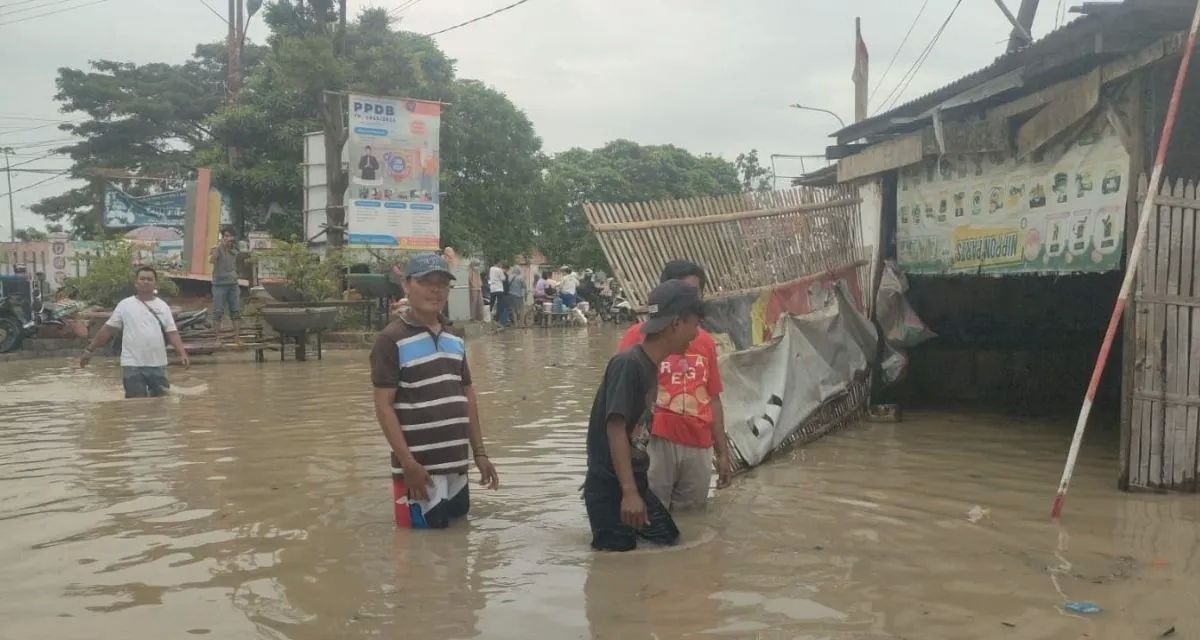 Banjir setinggi lutut orang dewasa masih menggenangi ruas jalan utama penghubung wilayah Kota dengan Kabupaten Bekasi di Desa Sriamur, Kecamatan Tambun Utara, Selasa siang.  <b>(Antara)</b>