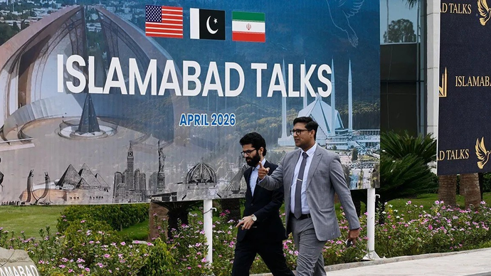 Orang-orang berjalan melewati pusat pers untuk pembicaraan antara Amerika Serikat dan Iran di Islamabad, Pakistan, Sabtu (114/2026). ANTARA/Xinhua/Wang Shen/aa.