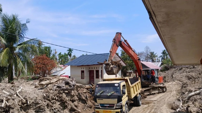 Eskavator sedang mengangkat lumpur kedalam truk yang menutupi rumah warga pascabencana banjir bandang akhir November 2025 lalu, di Pidie Jaya, Aceh, Minggu (5/4/2026). (ANTARA/Rahmat Fajri)