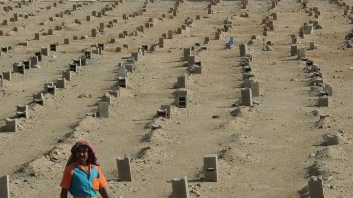 Seorang penjaga makam berjalan di pemakaman jamaah haji yang meninggal di Sharaya, Makkah.