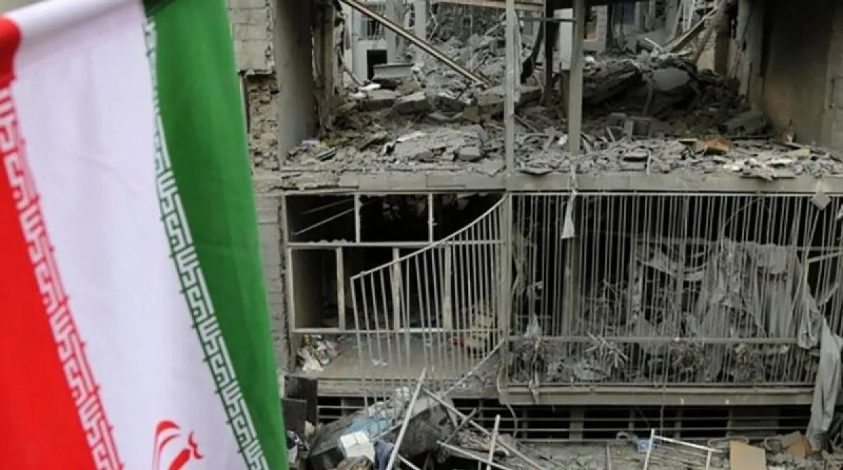 Arsip foto - Bendera Iran dengan kerusakan besar di distrik Javadiyeh dan Beryanak akibat serangan AS-Israel di Teheran, Iran, Mingu (15/3/2026). ANTARA/Anadolu/Fatemeh Bahrami/pri. <b>(Antara)</b>